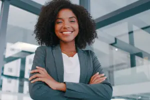 young woman standing in a strong pose, smiling